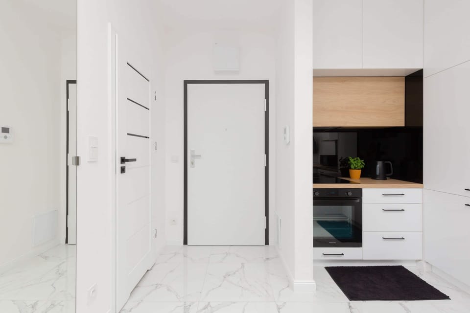 A bright hallway with white walls and doors leading to different rooms.