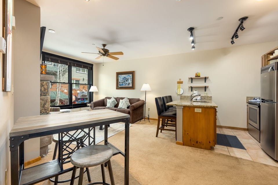 Relax in your open-concept living space with a cozy sofa, full kitchen, and mountain views from your window.