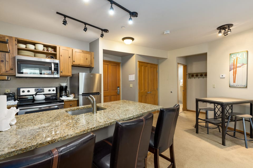 Your fully-equipped kitchen features granite counters, stainless steel appliances, and a breakfast bar perfect for morning coffee or casual meals together.