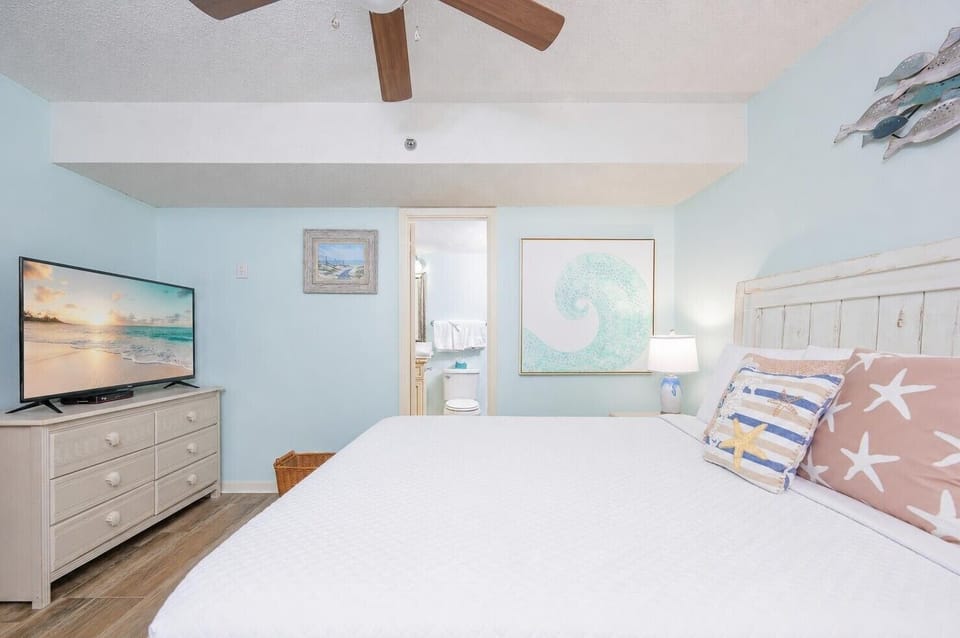 Relax on your soft king bed, enveloped by beach-inspired decor and the calming vibe of your suite