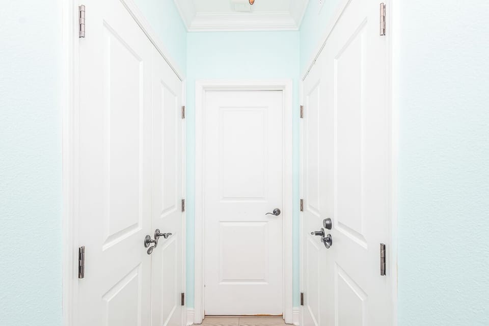 Step into your private hallway where crisp white doors lead to cozy rooms, creating a welcoming sense of home.