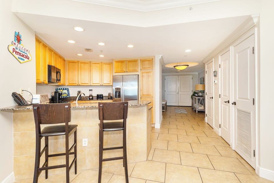 Your fully equipped kitchen features granite countertops, stainless steel appliances, and a breakfast bar perfect for casual dining and vacation meal prep.