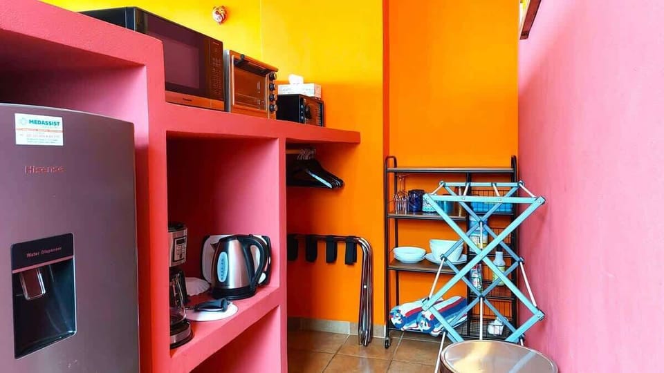 Master Bedroom (Miguel's Mirador) private kitchenette and closet area. Features, mid-size fridge with small freezer, microwave, toaster oven, personal safe, coffeemaker, electric kettle, drying rack, wood hangers, luggage racks, plates, glassware.