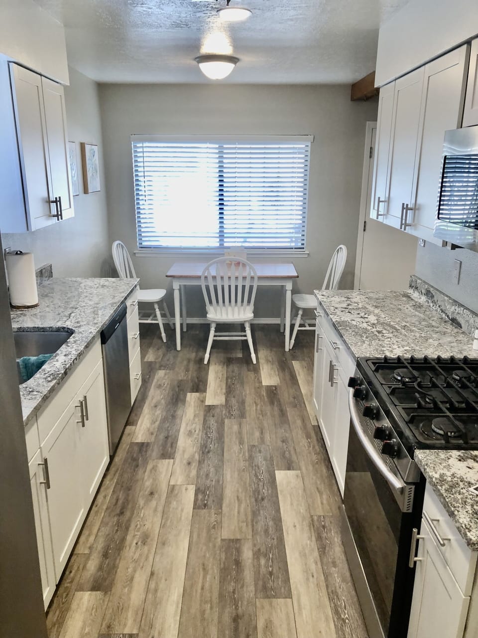 Kitchen with granite countertop’s & stainless steel appliances.