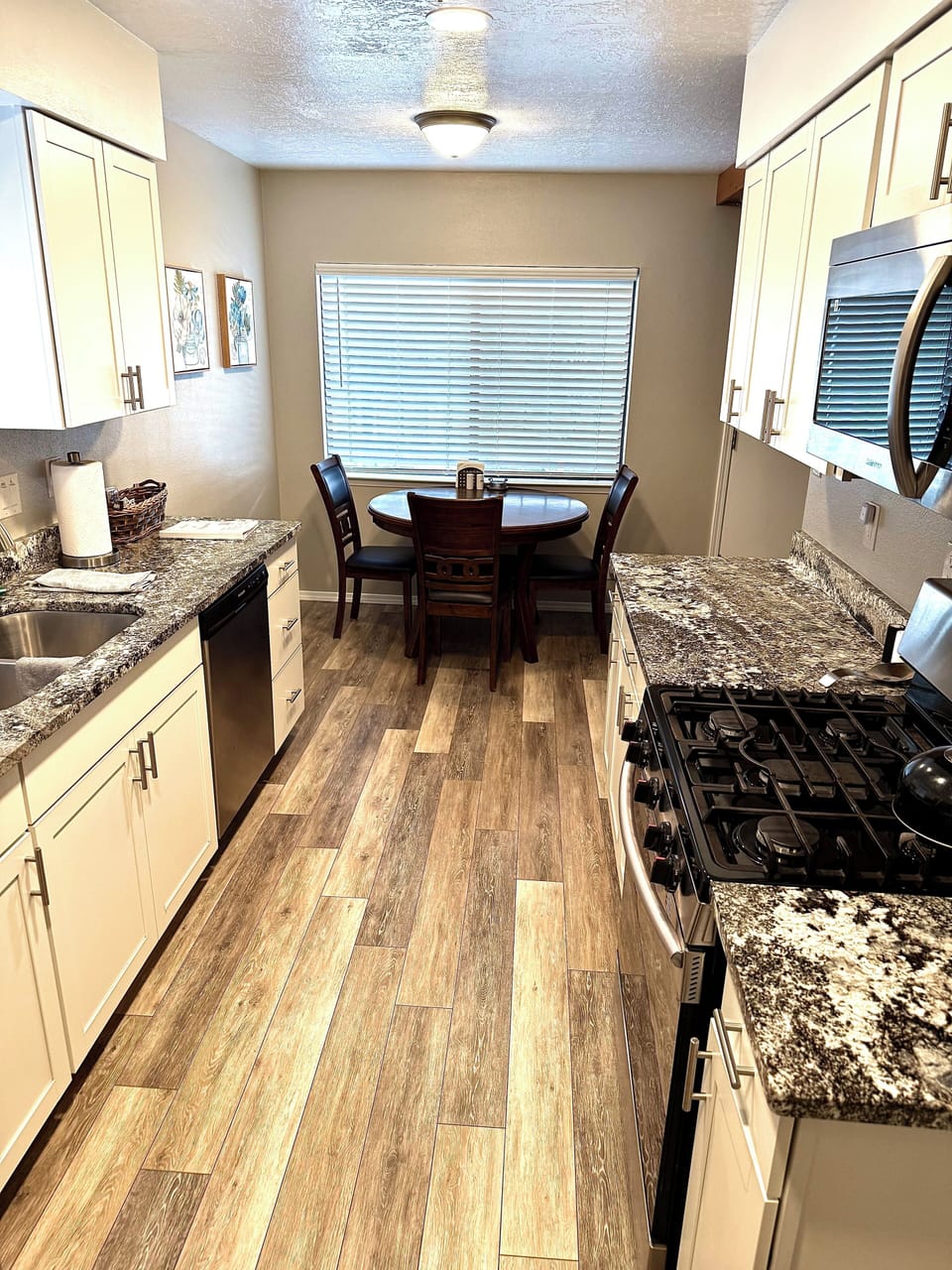 Kitchen with granite countertops, gas stove/oven and microwave 