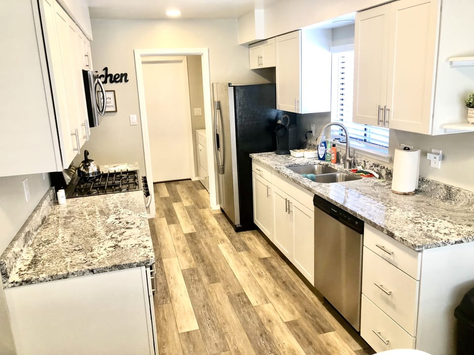 Kitchen with granite counters, stainless steel appliances.