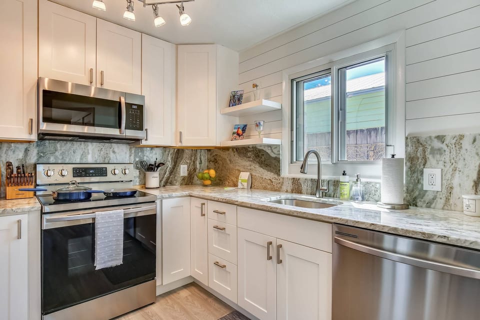 Sleek kitchen features modern appliances and marble countertops.