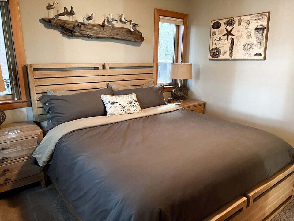 The primary bedroom has a king bed and luxurious ensuite bathroom. There is even a window seat to curl up on and look out at the trees and water beyond.