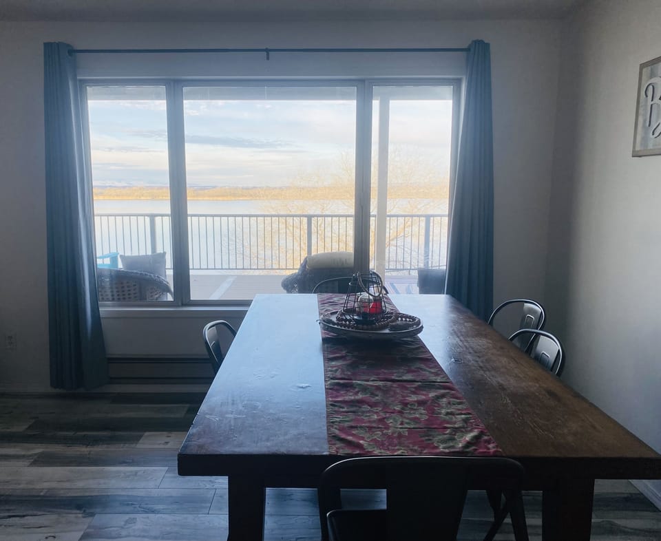 Dining area in living room with beautiful lake view.