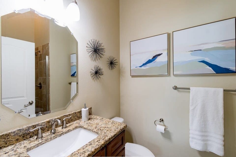 Modern bathroom with granite countertop and abstract wall art