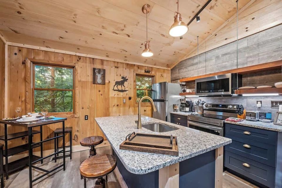 Cozy kitchen with modern appliances, granite countertops, and rustic wood finishes perfect for relaxed cabin dining.