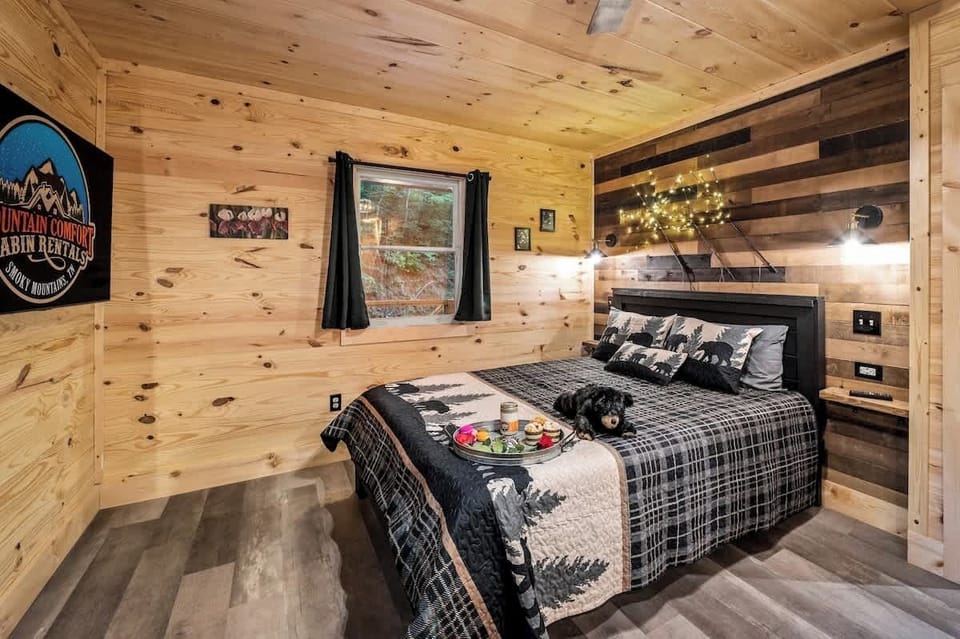 Cozy bedroom with a woodland theme, ambient string lights, and a plush bed perfect for a restful mountain retreat.