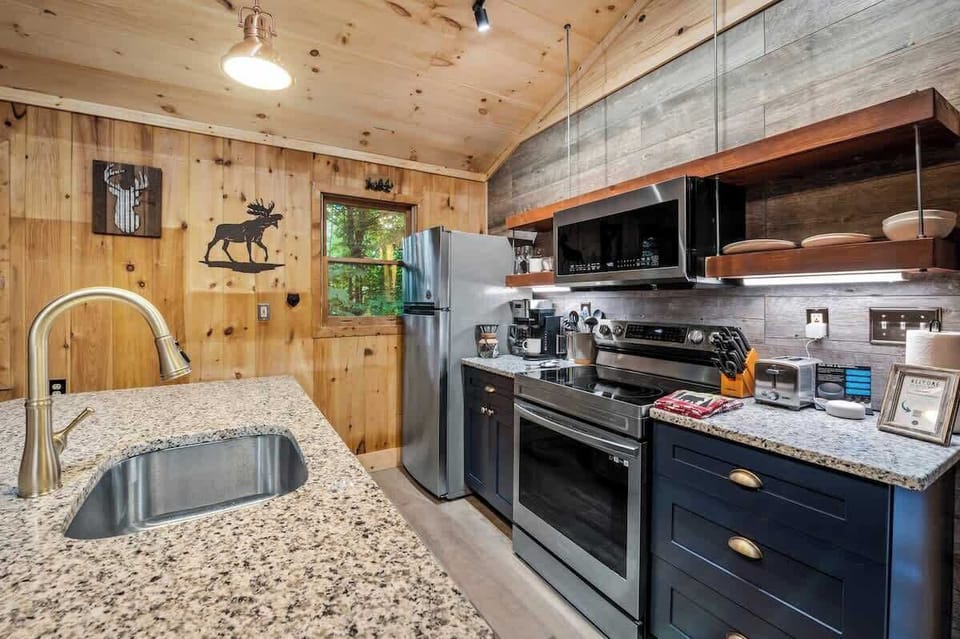 Fully equipped kitchen with stainless steel appliances, granite countertops, and rustic wood accents for a stylish and functional cooking space.