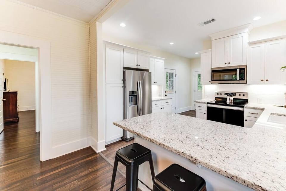 This kitchen is a haven for cuisine connoisseurs, featuring new kitchen cabinets and state-of-the-art appliances. Cook with ease using the oven, stove, microwave, and a suite of high quality cooking tools.