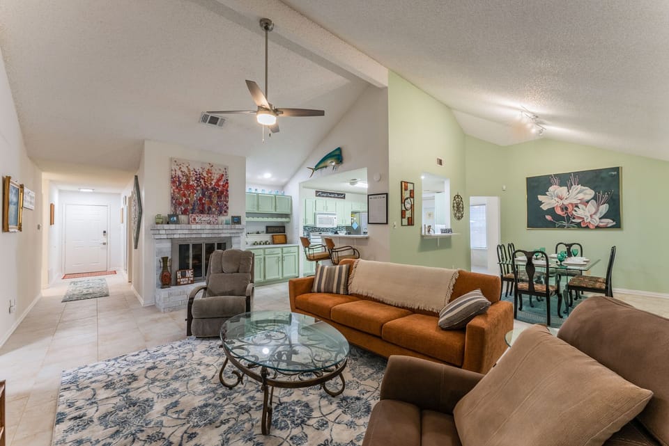 High-ceiling, open-space living room, with stone floors.