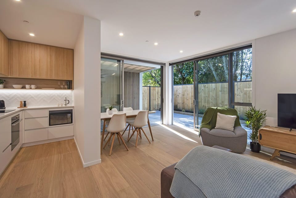 Kitchen - dining - living opening outdoor areas with garden and tree views