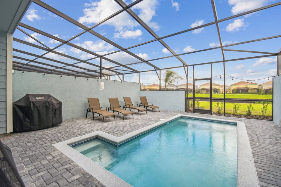 Step outside to your private oasis with a sparkling pool and sleek lounge chairs for sunbathing. The screened enclosure combines indoor comfort with outdoor enjoyment, all set against beautiful green views.