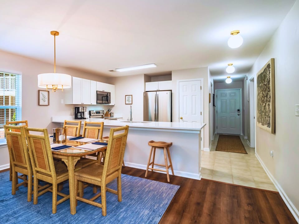 Dining area has six chairs and bar with 3 bar stools