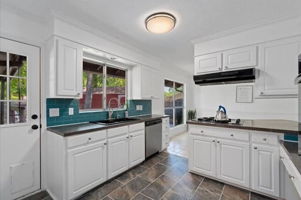 Full kitchen with gas stove, oven, sink, dishwasher, microwave, and three types of coffeemakers
