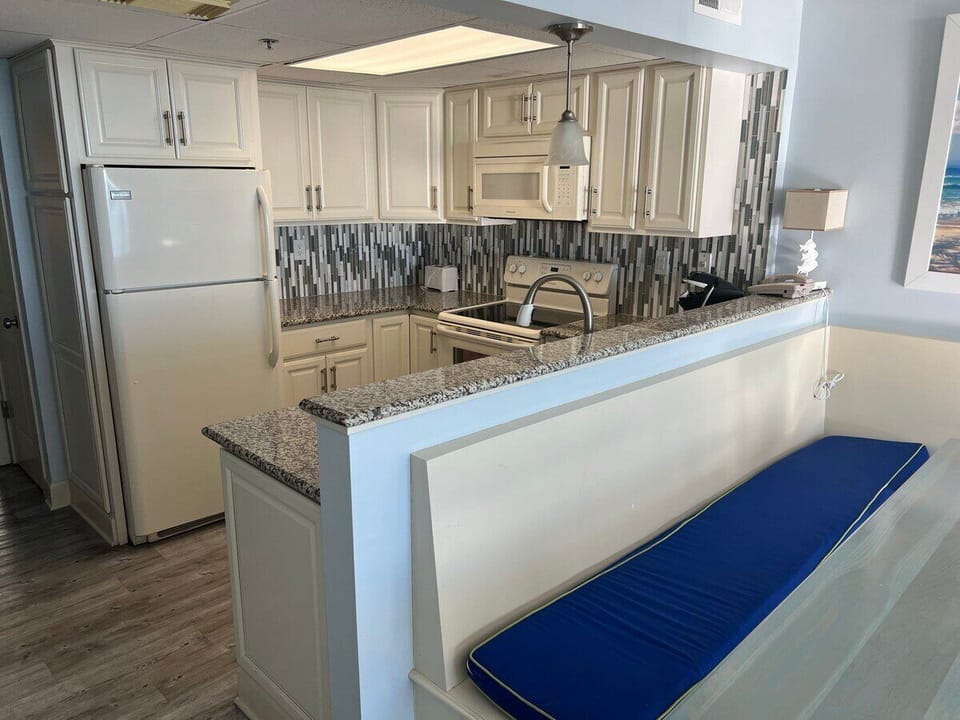 Full size appliances and Granite Counters with Bench around Dining Table