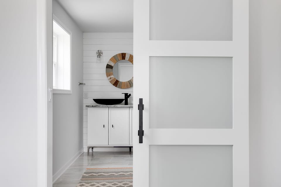 Modern barn door leads into the primary bathroom 