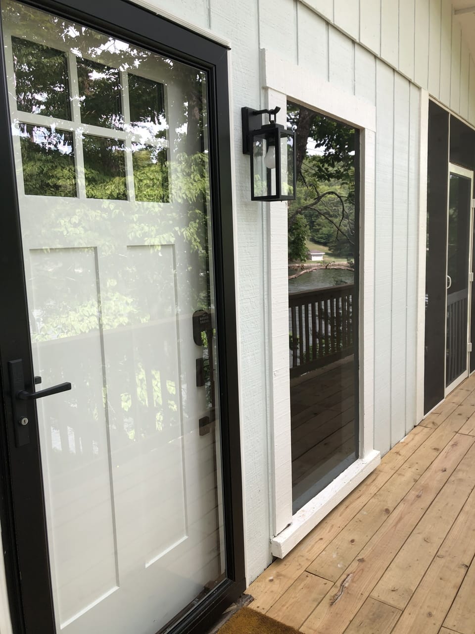 Side deck & front entry. Door to screened in deck with furniture & ceiling fans