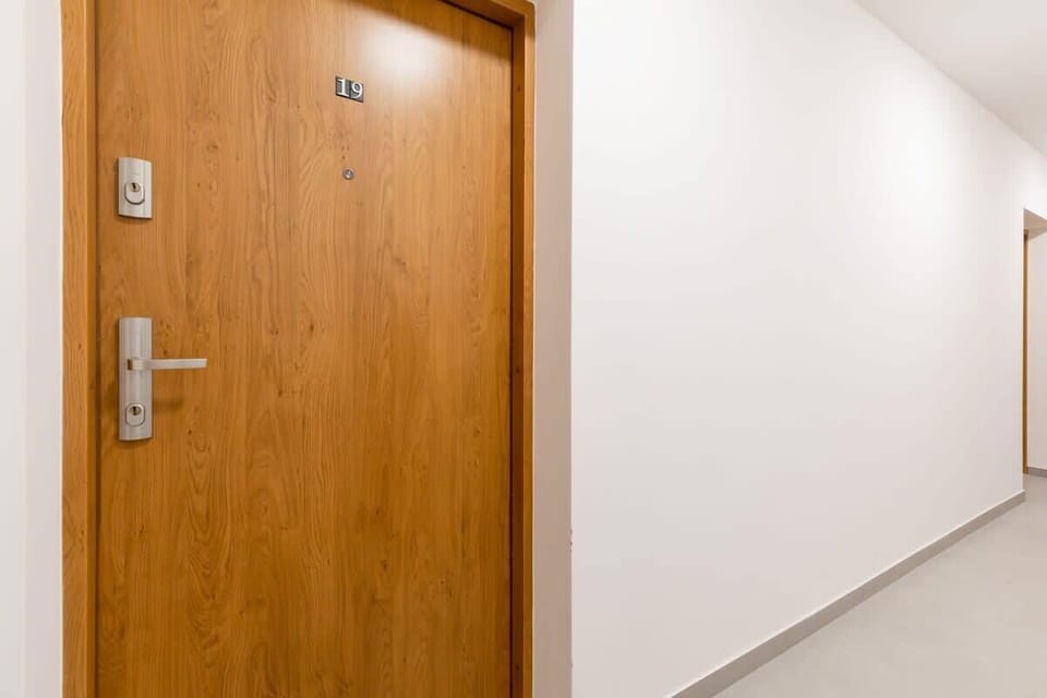 The building’s hallway with neutral tones, clean lines, and modern lighting, ensuring a welcoming entrance for guests.
