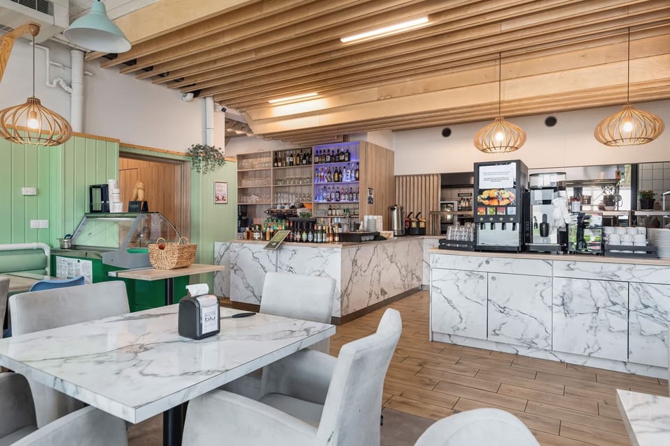 A charming cafe area with a marble counter and inviting decor, offering a cozy spot to relax.

