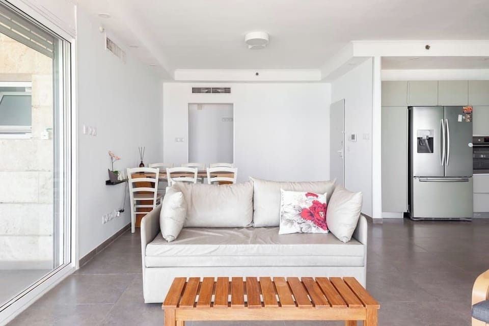 Open-plan living area blending modern design with calming seaside atmosphere.