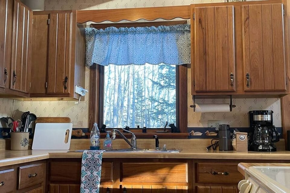 Enjoy a well-outfitted kitchen! Wash dishes at the sink with a view into the woods.