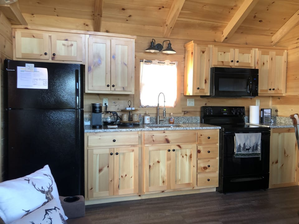 Kitchen area with refrigerator, range and microwave. And a Keurig coffee maker!