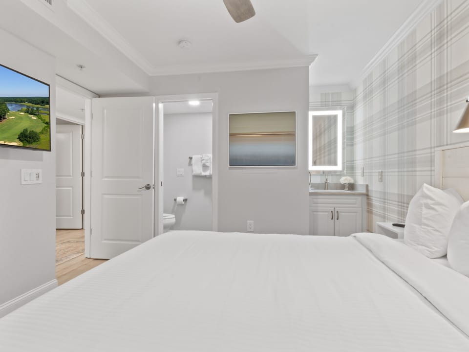 Wake up in your serene retreat with crisp white linens, an ensuite bathroom, and peaceful artwork creating the perfect sanctuary for rest.