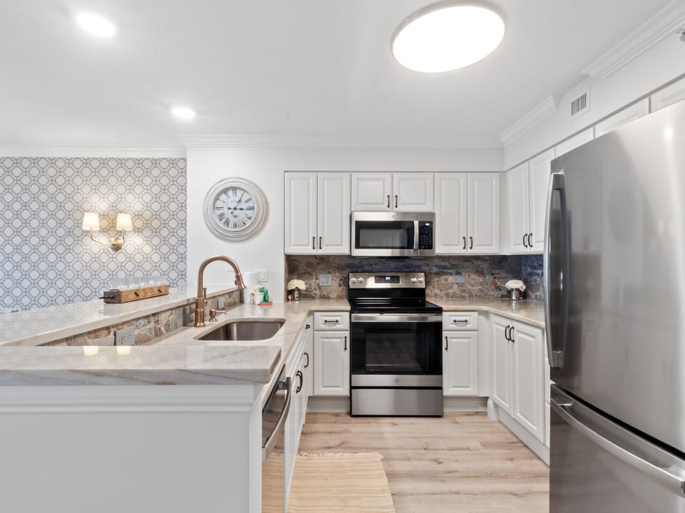 Your modern kitchen awaits with granite counters, stainless appliances, and charming patterned backsplash perfect for preparing memorable meals.
