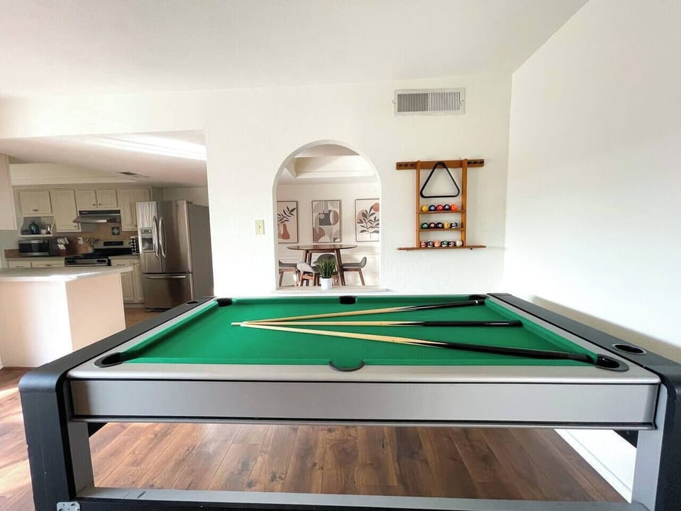 Classic billiard table, ready for a game, featuring rich green felt and polished wooden rails for a touch of elegance.