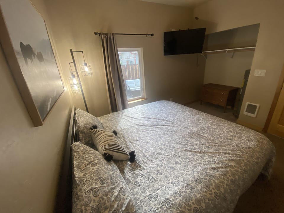 King size bedroom with a TV and dresser. 