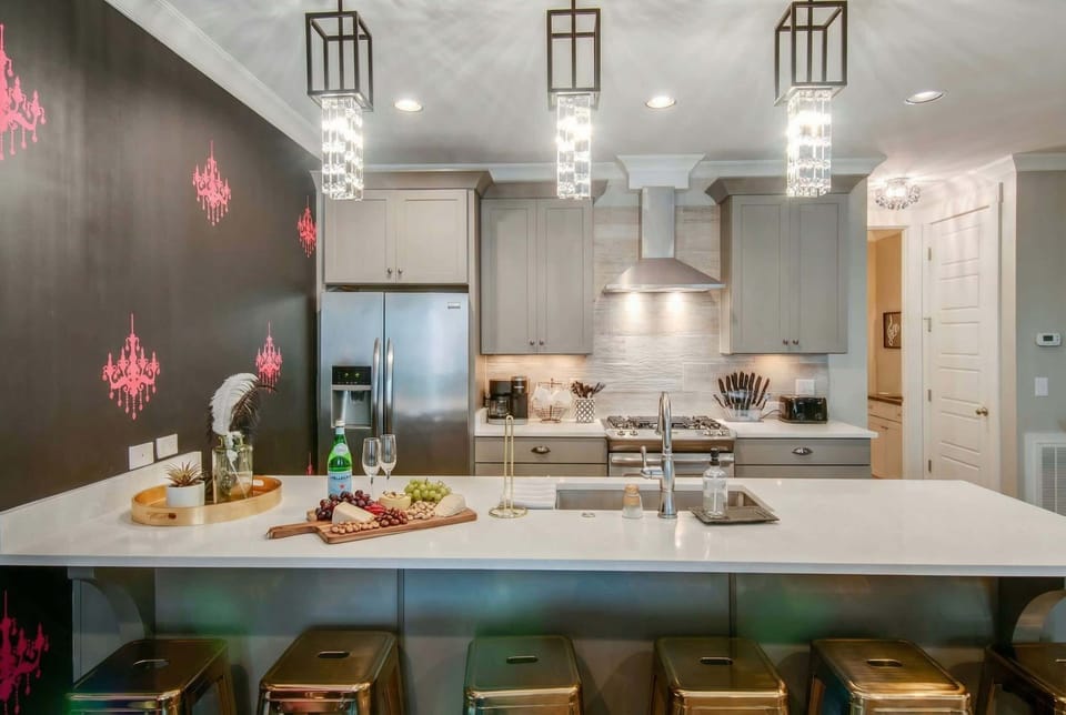 Discover this chic kitchen, perfect for a bachelorette party or family reunion in Nashville. Its elegant decor and spacious layout create an ideal setting for unforgettable getaways, whether cooking or relaxing with friends. Perfect for large groups seeking luxury!