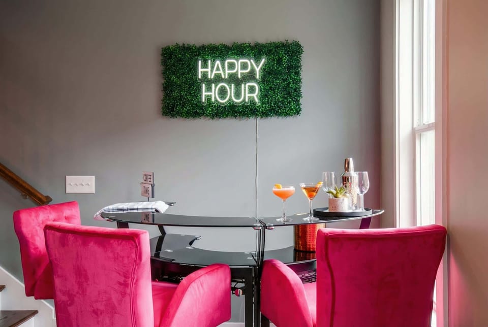 Glass bar table, pink chairs, and a happy hour neon sign mean your dining room doubles as the party hub, mix cocktails without leaving the house