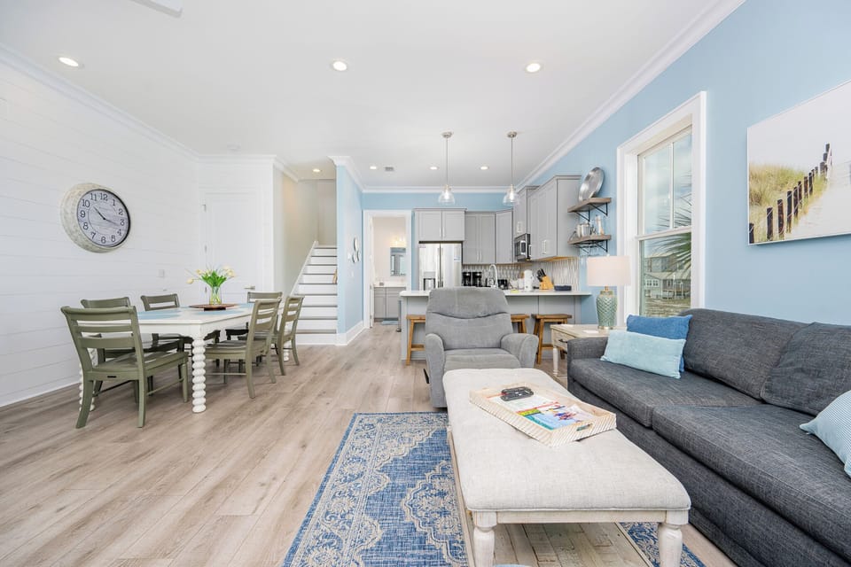 The living area features a cozy gray sofa, a stylish coffee table, and a dining space, perfect for relaxation and gatherings