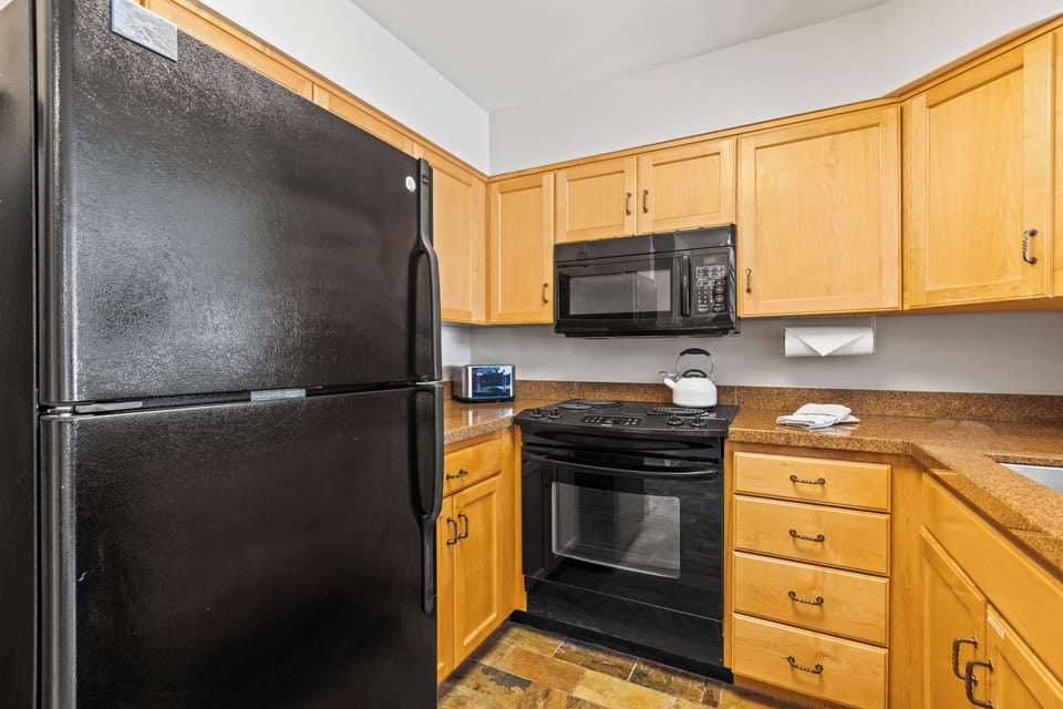 Resort Plaza 5051 offers a well-equipped kitchen with black appliances.
