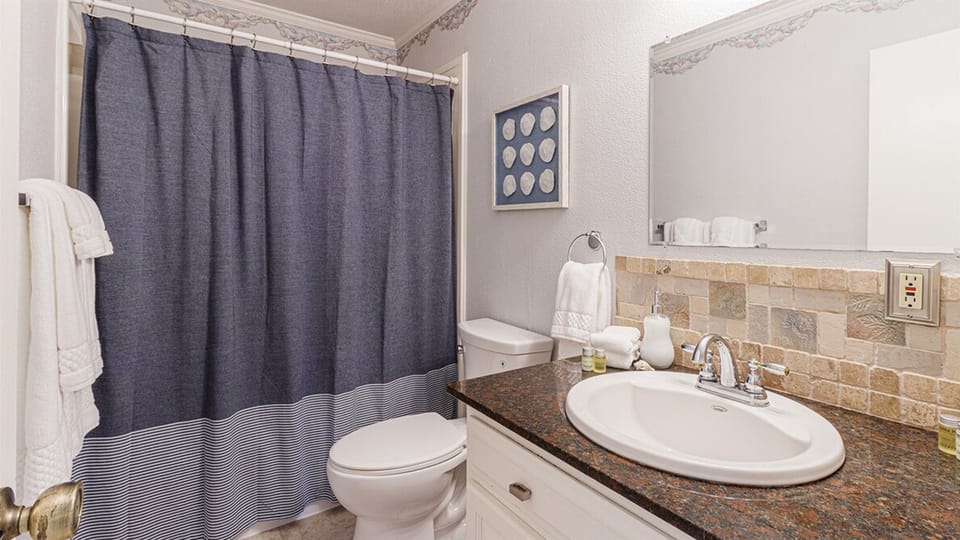 The second bathroom is located in the hallway.
