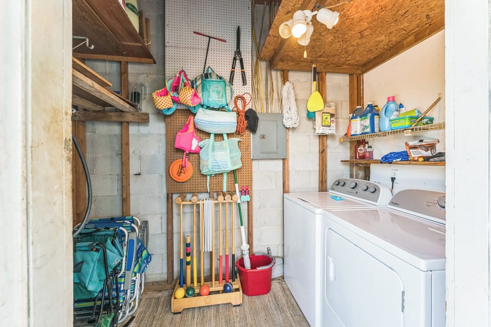 Laundry area with games, beach toys, beach chairs, and a wagon.