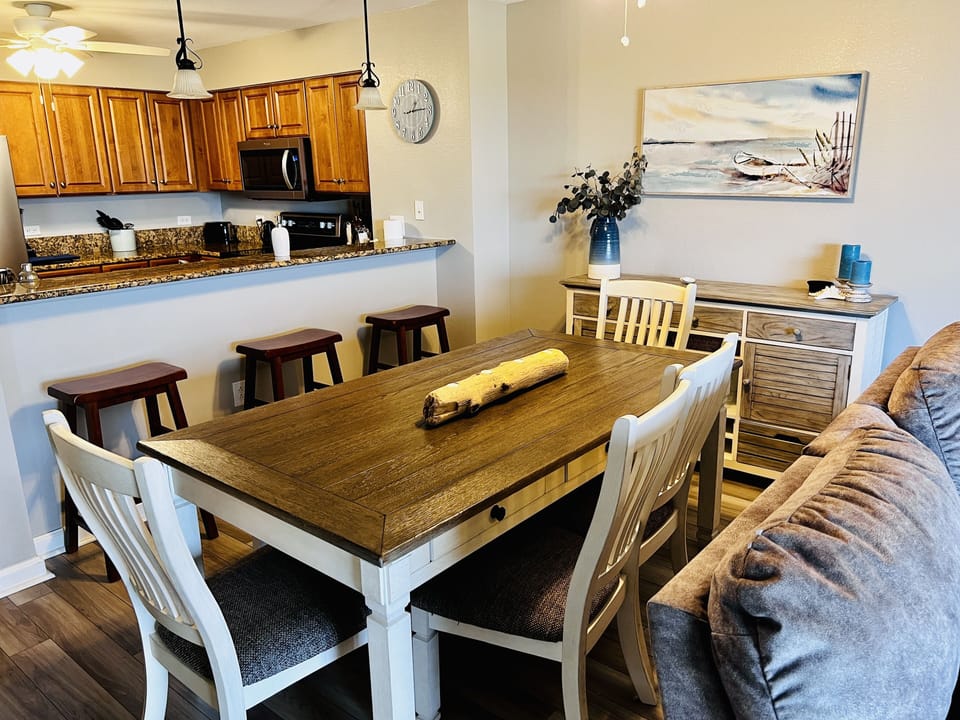 Gather around your spacious dining table where coastal charm meets comfort, with the full kitchen ready for memorable meals together.