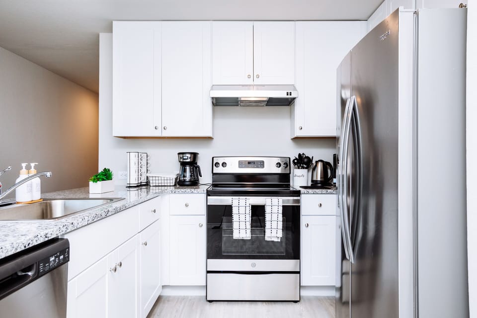 Modern kitchen is fully stocked and furnished with stainless steel appliances