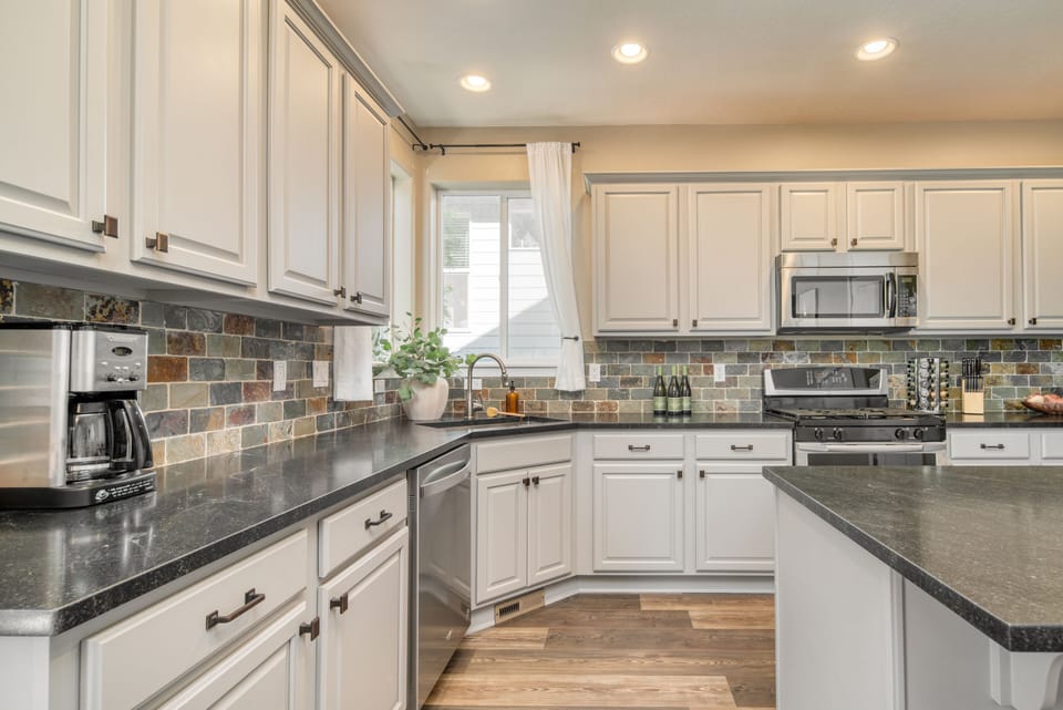 Modern appliances, including a microwave, dishwasher, stove, and coffee machine.