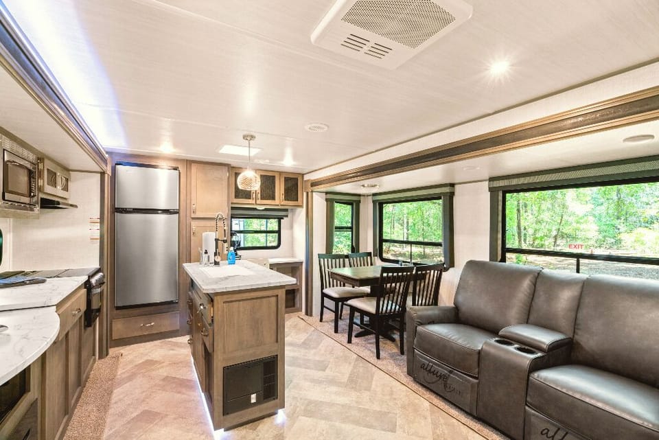 The Moto Ranch at Croom Vacation rentals The MX 1 bedroom 1 bath sleeps Three. kitchen, 3 burner propane stove, fridge/freezer, microwave, sink with cutting board cover. tv, and electric fireplace dining table, reclining chairs