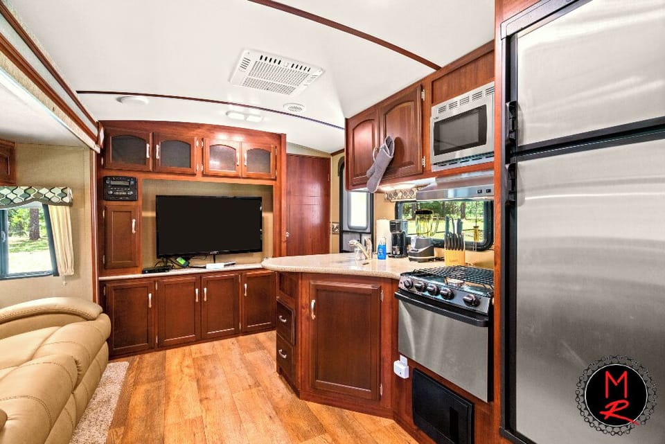 The Moto Ranch at Croom Vacation rentals ATV rv trailer 2 bedroom 1 bath sleeps 5. Living / dining area, sofa, dining table full kitchen, fridge/ freezer, gas stove, oven microwave, sink, and all kitchen ware/utensils 