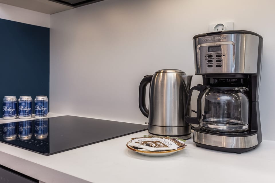 A close-up of the kitchen counter, featuring a coffee maker and complimentary bottled water.
