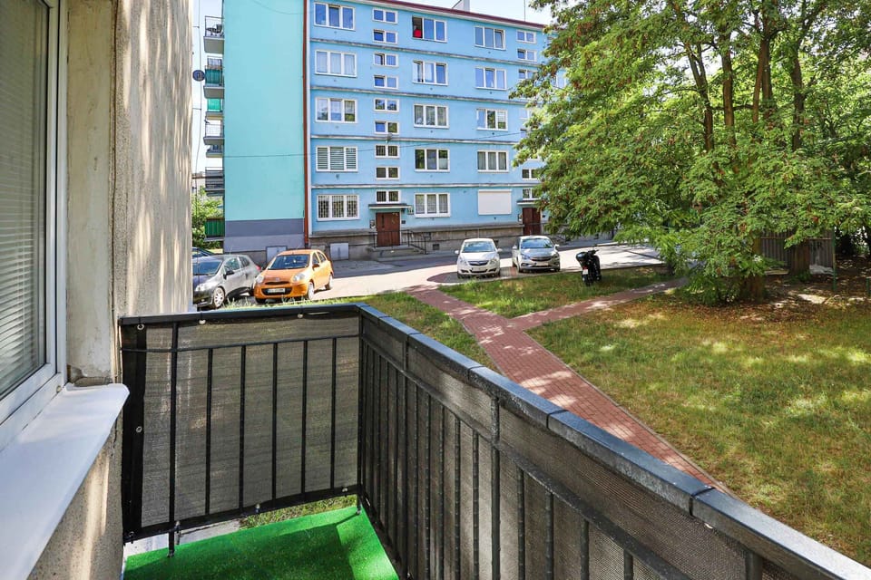 A view from the apartment balcony, overlooking a green courtyard, providing a relaxing outdoor space.

