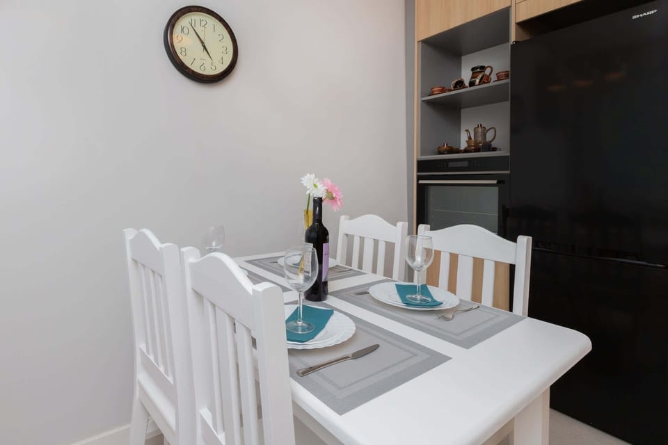 A close-up of the dining area with a white table, chairs, and decorative accents, adding charm to the kitchen space.
