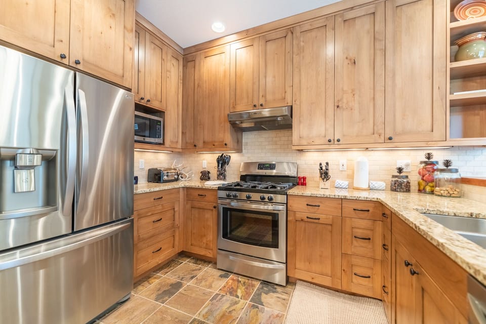 Full size kitchen with granite countertops and stainless steel appliances.